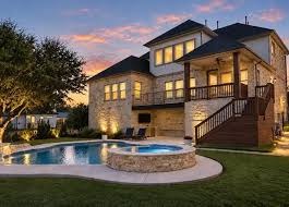 Two-story home with a pool at dusk in Leander Estates, Leander, Texas